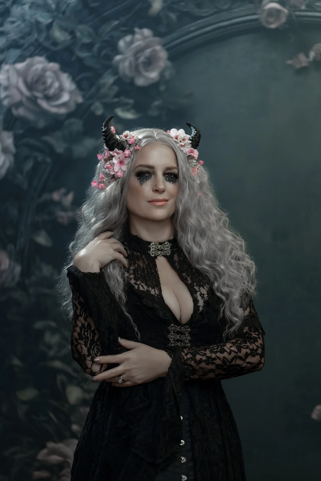 Woman in black lace with silver hair and a floral horned headpiece before the Victorian Gothic Frame with Flowers backdrop