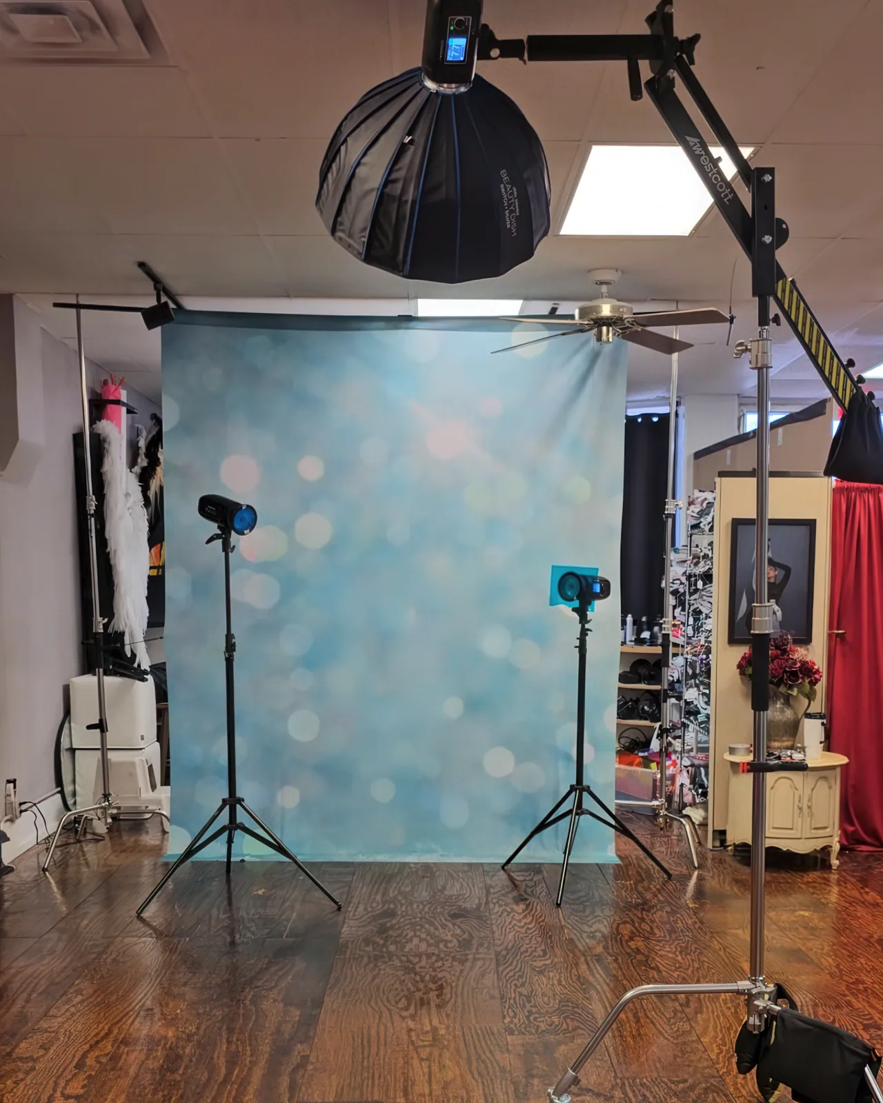 Boom-mounted light shaping a blue-background portrait — behind the scenes