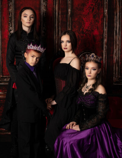 Gothic family gathered closely together in coordinated black and purple attire.