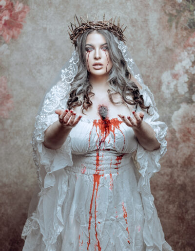 Haunting conceptual portrait of a ghostly bride in a blood-streaked white gown
