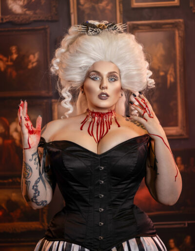 Vintage-inspired white-haired woman wearing a black corset and red statement jewelry