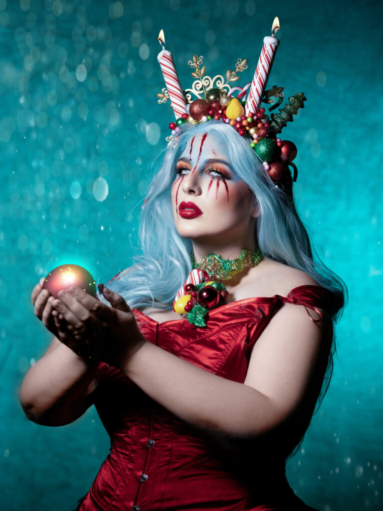 Blue-haired winter queen holding a dark crystal orb