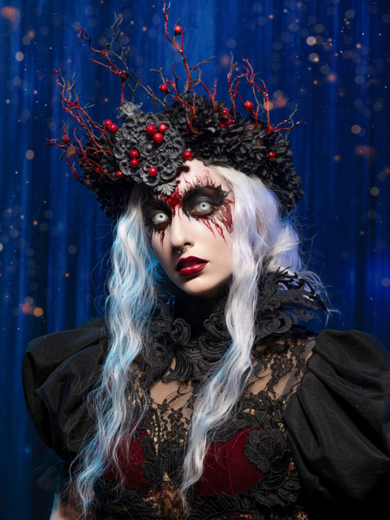 Dark winter queen wearing a black crown accented with red berries