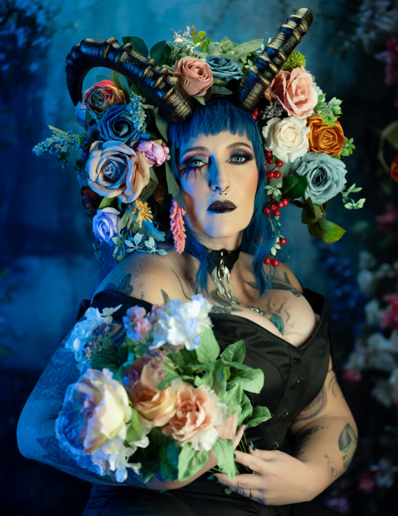Blue and green floral goddess surrounded by an elaborate bouquet