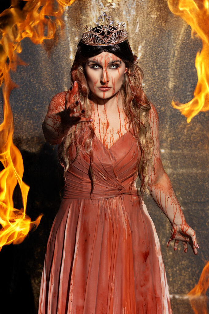 Powerful fire queen in an orange gown surrounded by flames