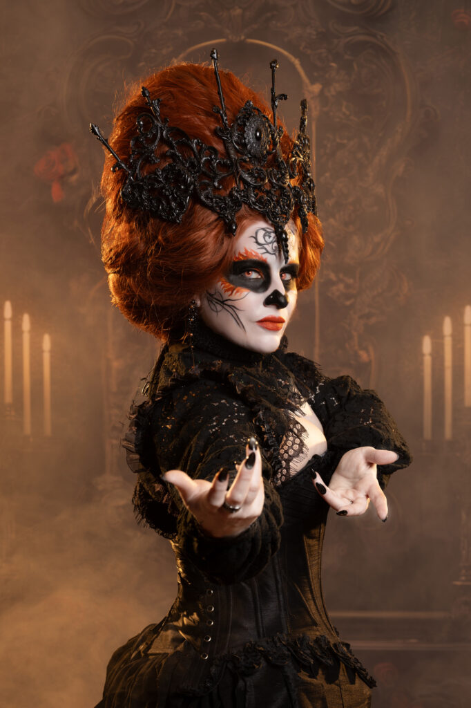 Red-haired Victorian fantasy woman in an ornate black costume and headpiece