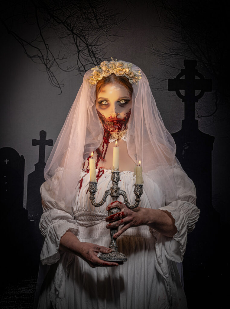 A bloody zombie bride lit with candles