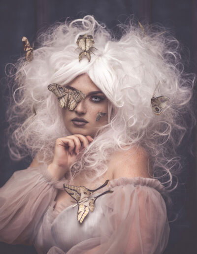A beautiful freckled model with white hair and moths