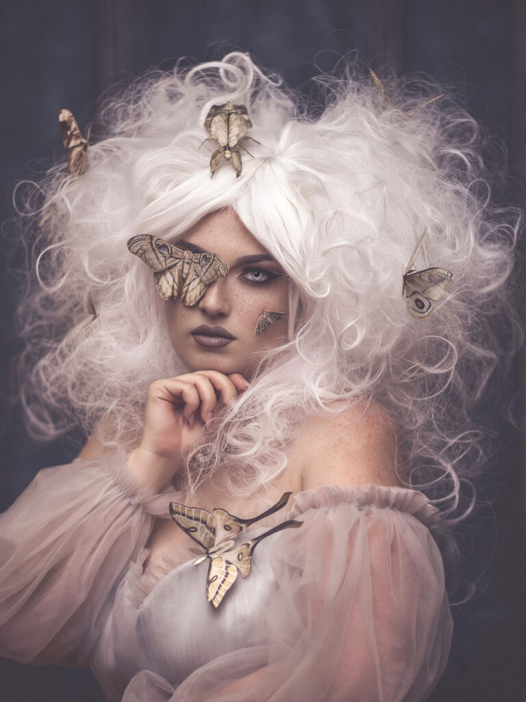 A beautiful freckled model with white hair and moths