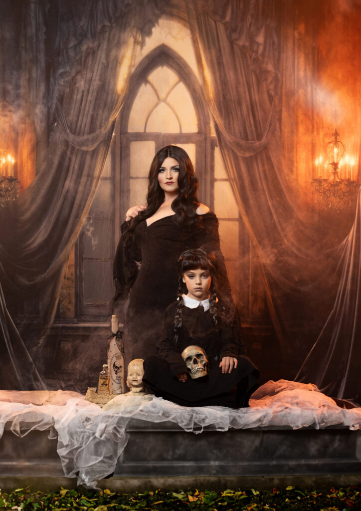 Gothic woman in black posed with a creepy Victorian doll