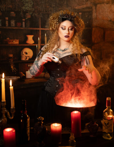 Victorian witch creating smoke over a bowl in a candlelit room