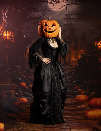 Pumpkin-headed figure standing in a dark candlelit Halloween setting