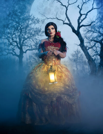 Red-cloaked gothic woman holding a lantern in a misty forest