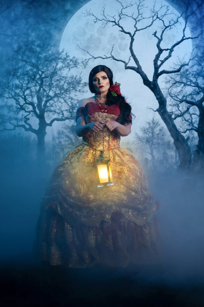 Red-cloaked gothic woman holding a lantern in a misty forest