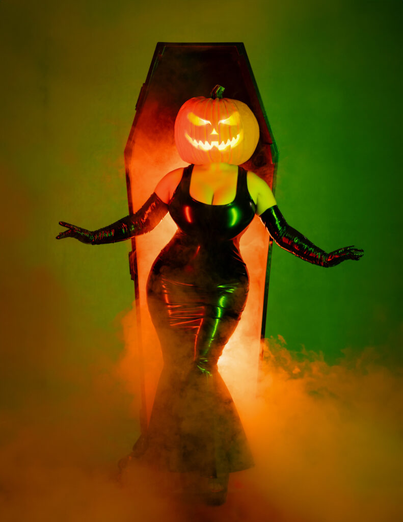 Pumpkin-headed Halloween character illuminated by green and orange light