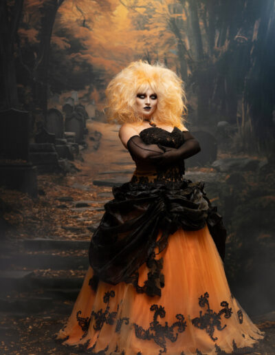 Dark romantic portrait of a blonde woman in black surrounded by autumn woods