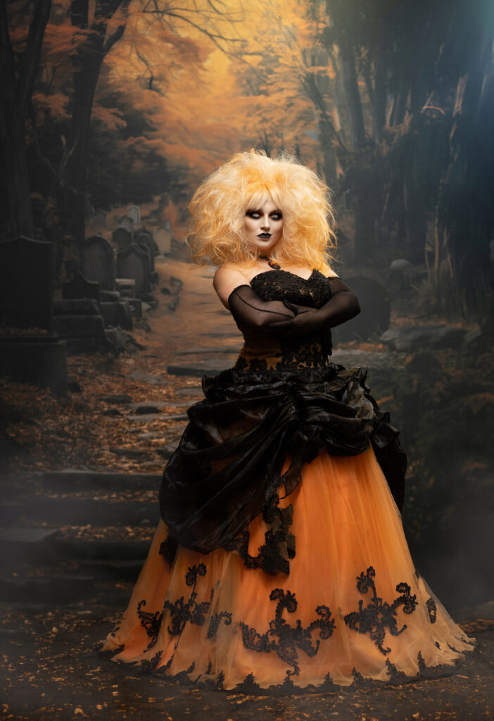 Dark romantic portrait of a blonde woman in black surrounded by autumn woods