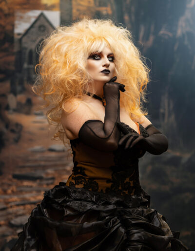 Blonde gothic character with dramatic hair and a black ruffled costume
