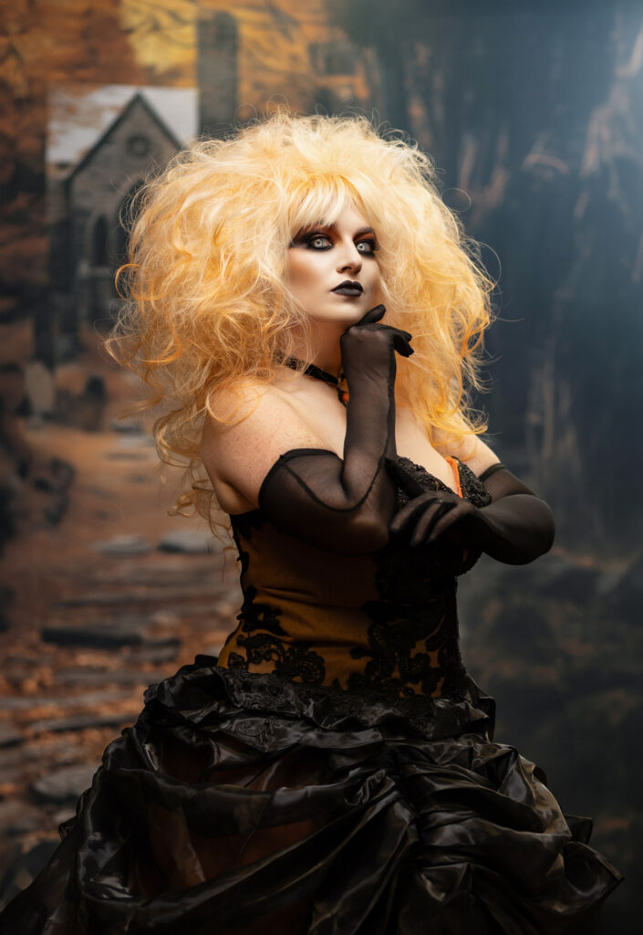 Blonde gothic character with dramatic hair and a black ruffled costume