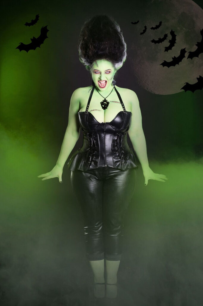 Green-skinned gothic character wearing a black corset against a glowing green background.