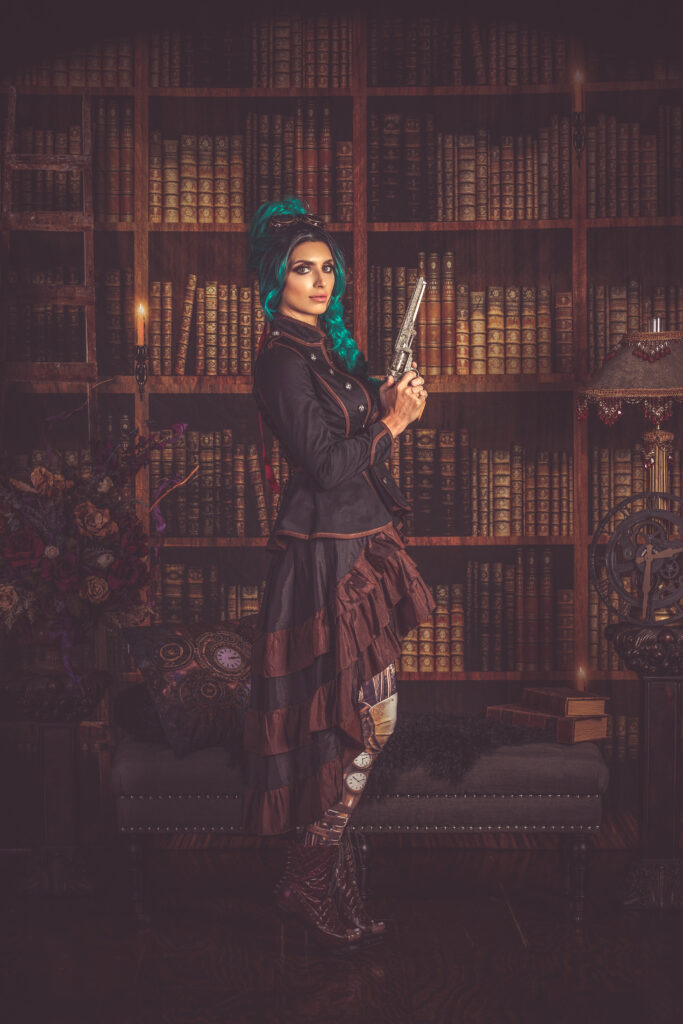 Teal-haired woman in a burgundy steampunk jacket holding a pistol in front of bookshelves.