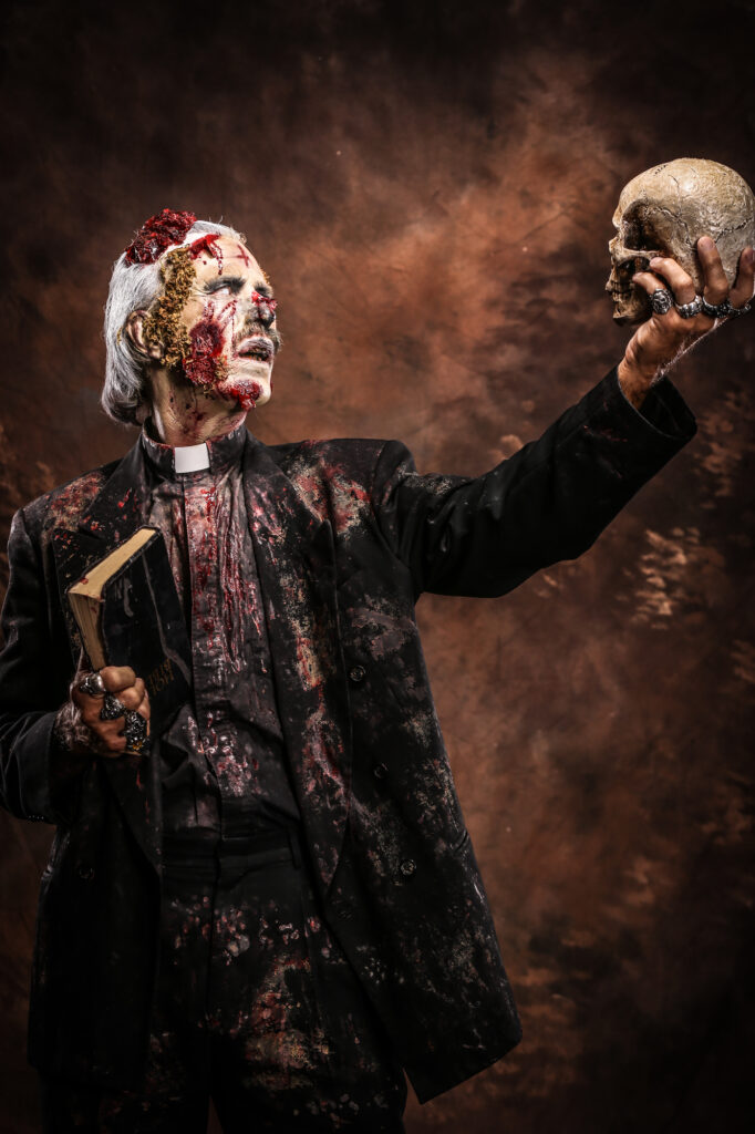 Blood-covered masked horror character reaching forward against a smoky brown background.